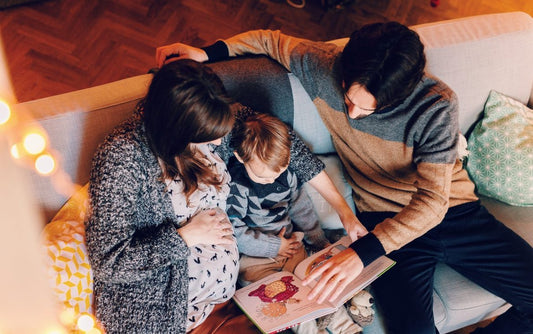 2 parents lisant une histoire à leur enfant