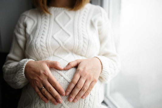 une femme enceinte posant ces mains sur son ventre
